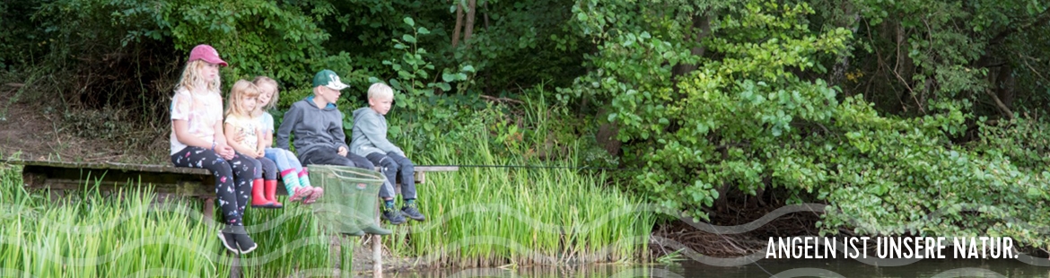 Zwei Kinder erforschen das Seeufer von einem Steg.