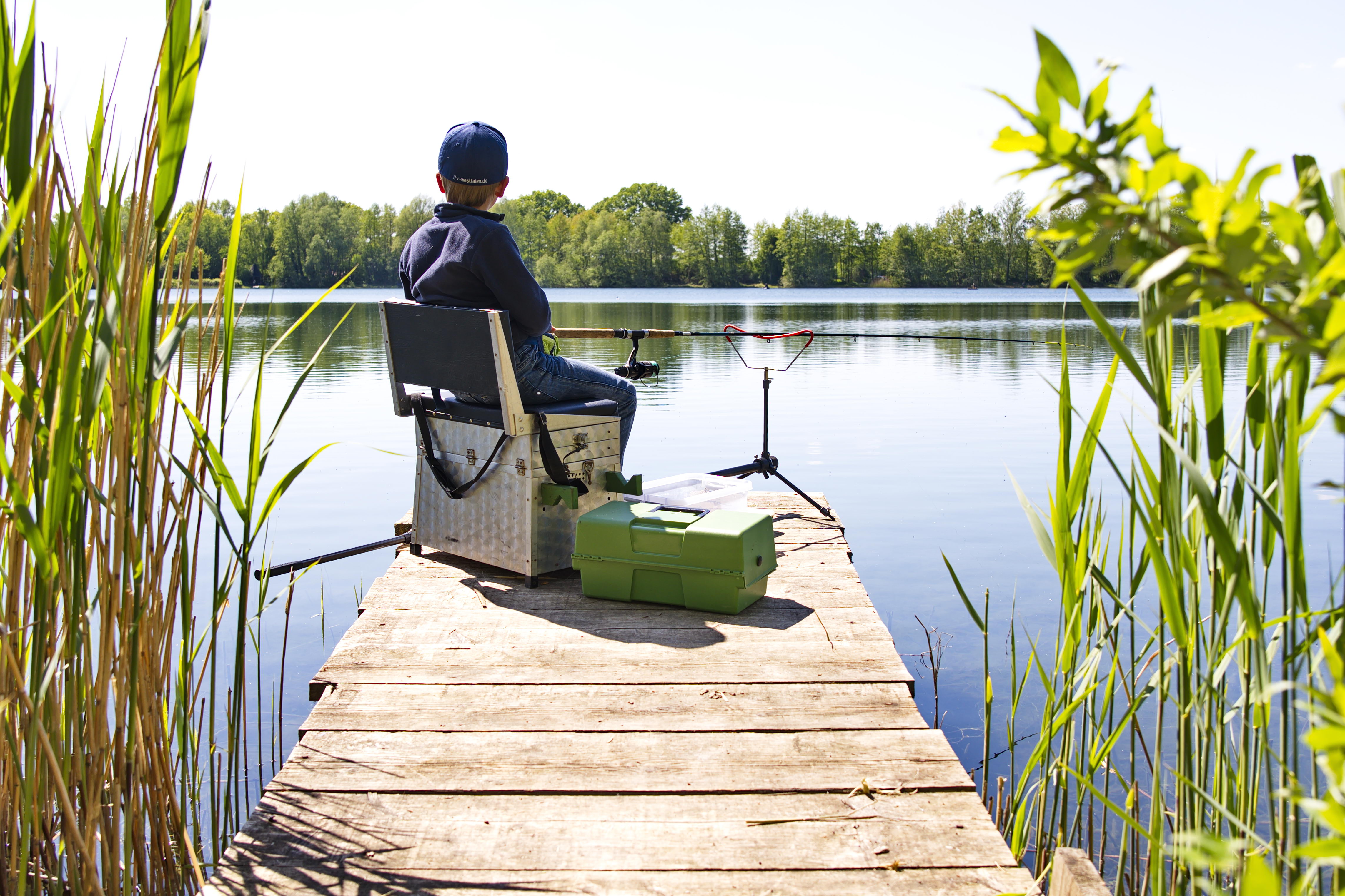 Ein Kind angelt auf einem Steg